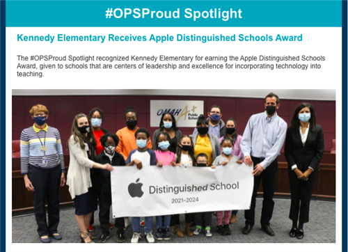 A group hold the Apple Distinguished Schools Banner from the Board Meeting